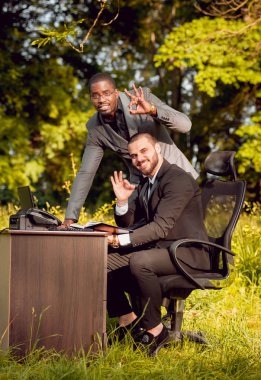 Parkta iş adlı iki genç çok kültürlü businessmans. Uzak iş kavramı.