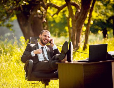 Genç işadamı park içinde işte. Uzak iş kavramı.