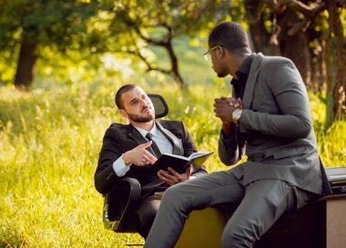 Parkta iş adlı iki genç çok kültürlü businessmans. Uzak iş kavramı.