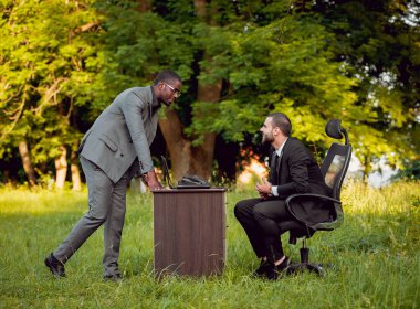 İki genç çok kültürlü iş adamları iş park yerinde. Uzak iş kavramı.