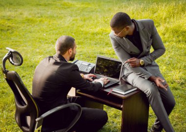 Parkta iş adlı iki genç çok kültürlü businessmans. Uzak iş kavramı.