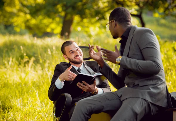 Parkta iş adlı iki genç çok kültürlü businessmans. Uzak iş kavramı.