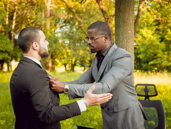 İki genç çok kültürlü iş adamları iş park yerinde. Uzak iş kavramı.