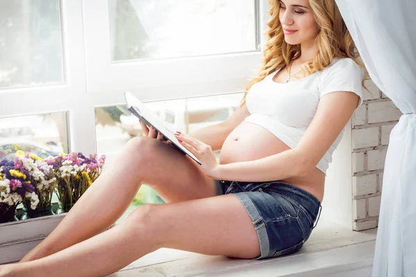 年轻孕妇读一本书 — 图库照片
