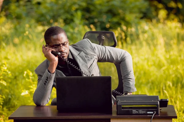 Park içinde İşte genç Afro-Amerikalı iş adamı. Uzak iş kavramı.