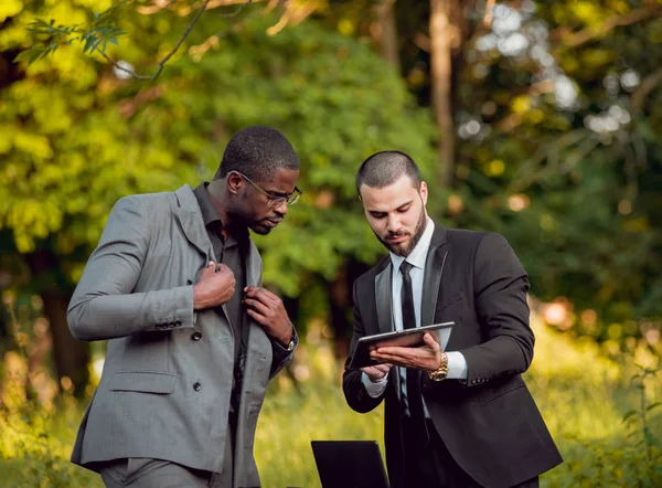 İki genç çok kültürlü iş adamları iş park yerinde. Uzak iş kavramı.