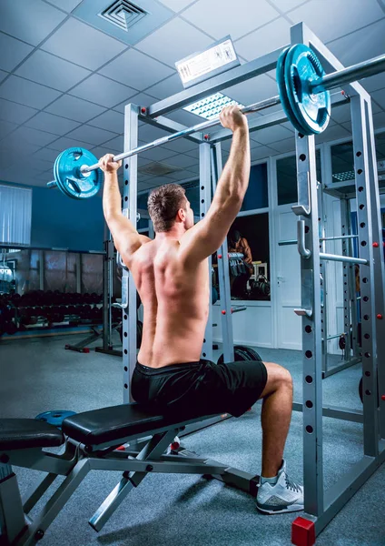 Barbell ile spor salonunda genç kaslı adam