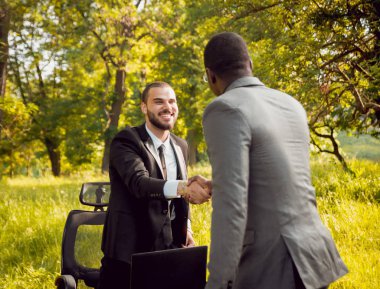 Parkta iş adlı iki genç çok kültürlü businessmans. Uzak iş kavramı.