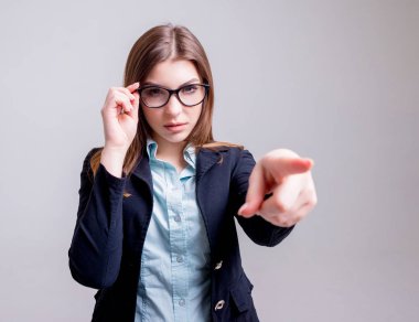 Önce hafif gri duvar gözlüklü genç iş kadını