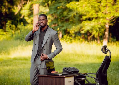 Park içinde İşte genç Afro-Amerikalı iş adamı. Uzak iş kavramı.