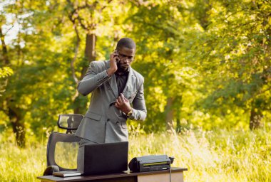 Park içinde İşte genç Afro-Amerikalı iş adamı. Uzak iş kavramı.