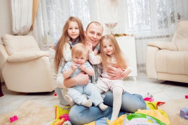 Baba evde çocuklarıyla oynuyor.