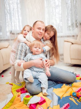 Baba evde çocuklarıyla oynuyor.