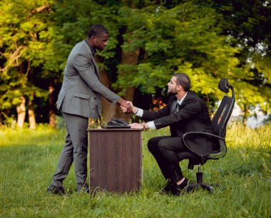 İki genç çok kültürlü iş adamları iş park yerinde. Uzak iş kavramı.