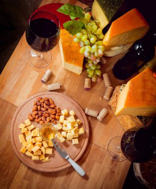Tahta bir masada peynir ve şarap.