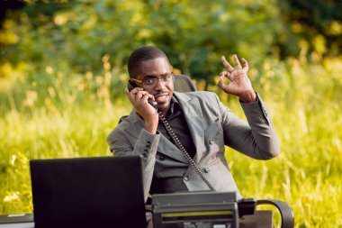 Park içinde İşte genç Afro-Amerikalı iş adamı. Uzak iş kavramı.