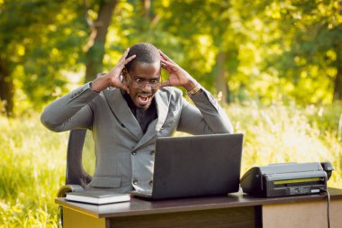 Park içinde İşte genç Afro-Amerikalı iş adamı. Uzak iş kavramı.
