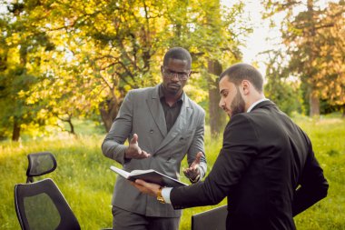 Parkta iş adlı iki genç çok kültürlü businessmans. Uzak iş kavramı.