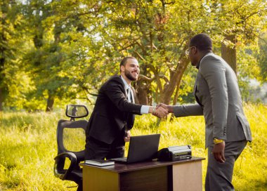 Parkta iş adlı iki genç çok kültürlü businessmans. Uzak iş kavramı.