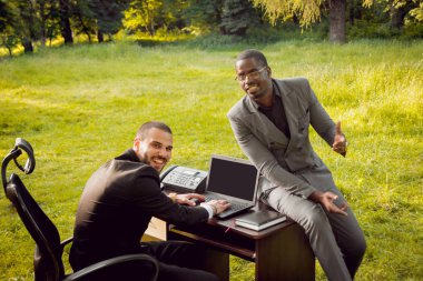 Parkta iş adlı iki genç çok kültürlü businessmans. Uzak iş kavramı.