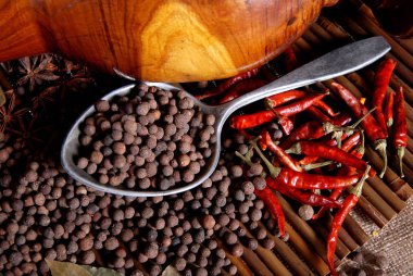 Bambu üzerinde bir kaşık ve kırmızı chilie siyah biber biber