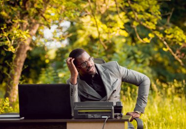 Genç işadamı park içinde işte. Uzak iş kavramı.