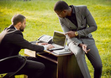 Parkta iş adlı iki genç çok kültürlü businessmans. Uzak iş kavramı.