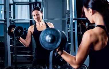 Genç esmer kadının spor salonunda egzersiz yapması.