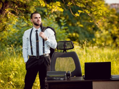 Genç işadamı park içinde işte. Uzak iş kavramı.