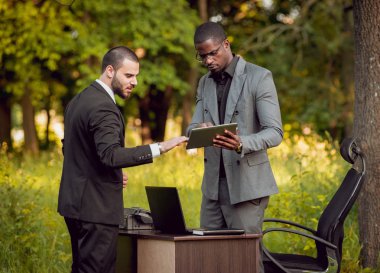 İki genç çok kültürlü iş adamları iş park yerinde. Uzak iş kavramı.