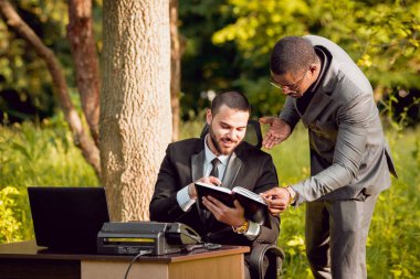 İki genç çok kültürlü iş adamları iş park yerinde. Uzak iş kavramı.