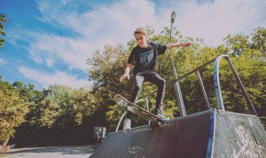 Young skateboarder doing tricks in skate park. clipart