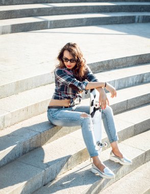 Genç esmer kız açık havada kaykay ile poz