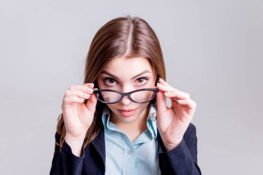 Önce hafif gri duvar gözlüklü genç iş kadını