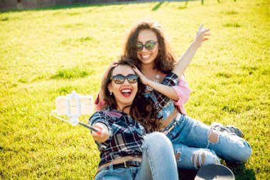 İki genç karışık yarış kız açık havada kaykay ile selfie yapıyor