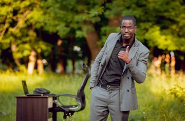 Park içinde İşte genç Afro-Amerikalı iş adamı. Uzak iş kavramı.