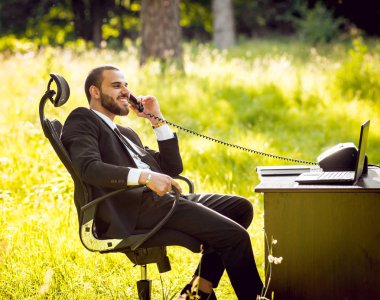 Genç işadamı park içinde işte. Uzak iş kavramı.