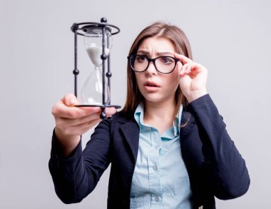 Bir kum saati tutan genç iş kadını. Son tarih kavramı.