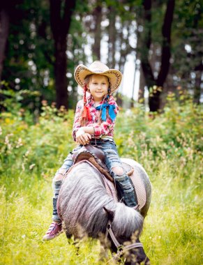 Park midilli sürme kovboy şapkalı örgü ile küçük kız
