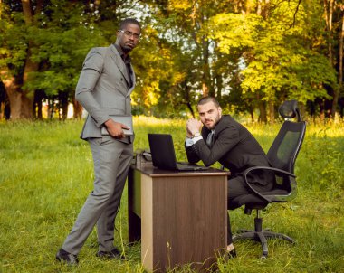 Parkta iş adlı iki genç çok kültürlü businessmans. Uzak iş kavramı.