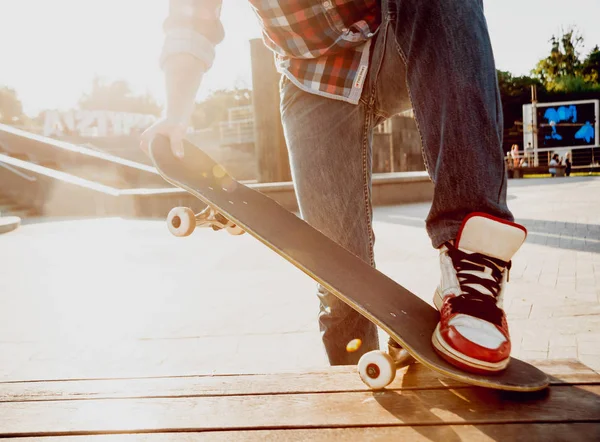 Cropped image of young man riding skateboard on town square