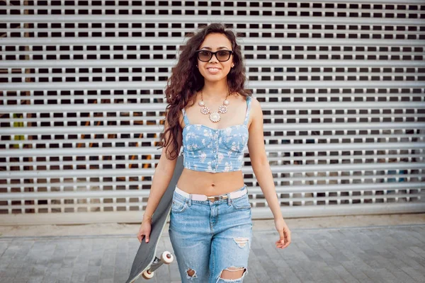 Genç karışık yarış kız açık havada kaykay ile poz