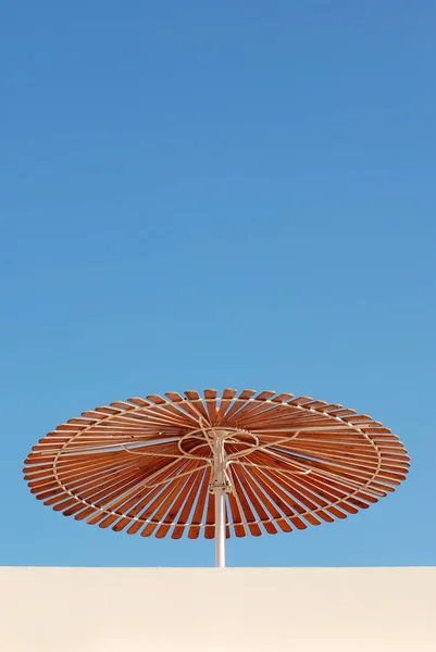 Low angle of sun umbrella with clear sky.