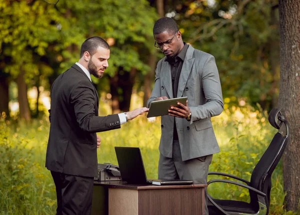 İki genç çok kültürlü iş adamları iş park yerinde. Uzak iş kavramı.