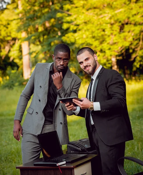 İki genç çok kültürlü iş adamları iş park yerinde. Uzak iş kavramı.