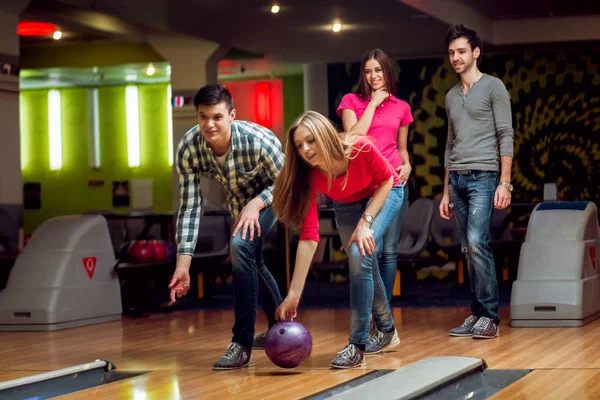 Cheerful friends at the bowling alley with balls