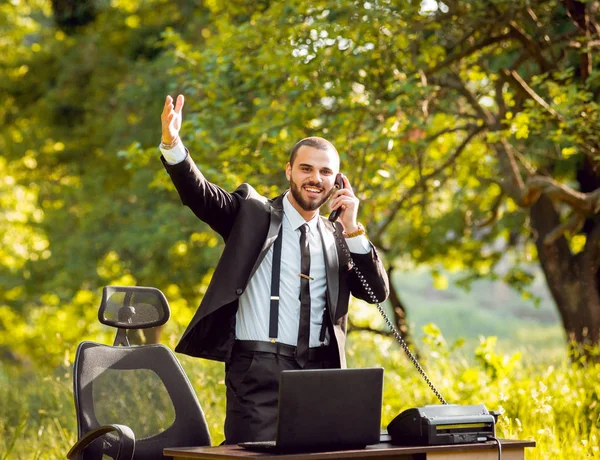 Genç işadamı park içinde işte. Uzak iş kavramı.