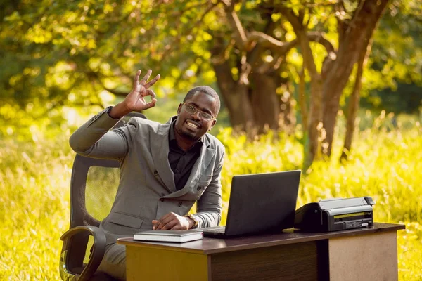 Young african american businessman at work in park. Concept of remote work.