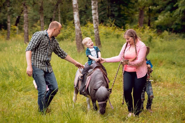 愉快的家庭步行与小马在公园 — 图库照片