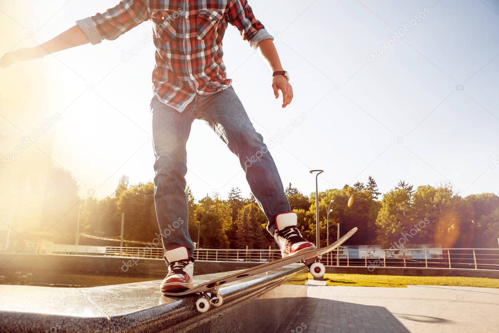 Cropped image of young man riding skateboard on town square